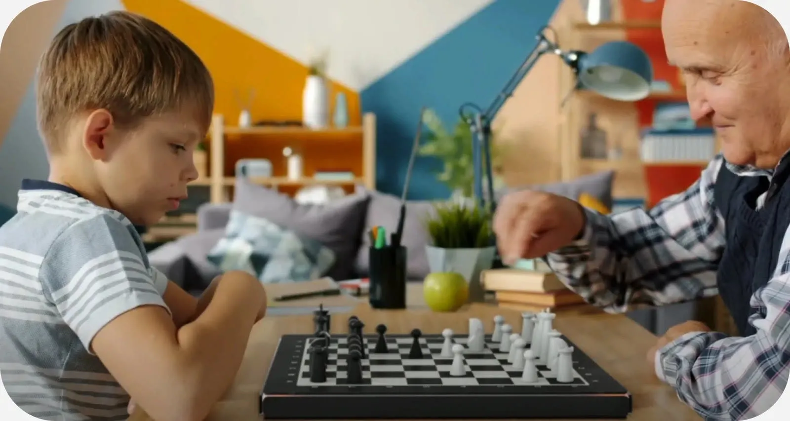 A grandfather and grandson playing GoChess at a kitchen table